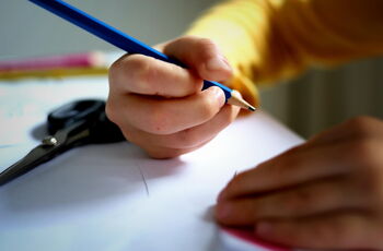Foto: Hände eines Kindes mit Bleistift in der Hand