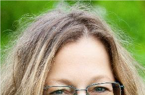 Foto einer lächelnden Frau mit blonden Haaren und Brille